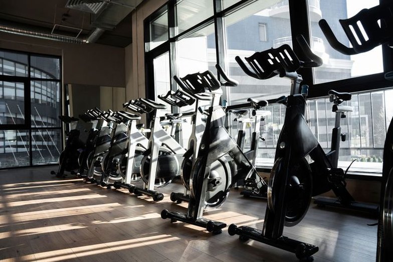 Rows of spin bikes in a sunlit studio