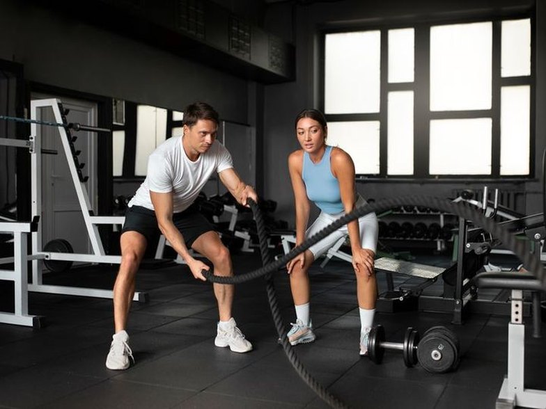 Two members training with battle ropes