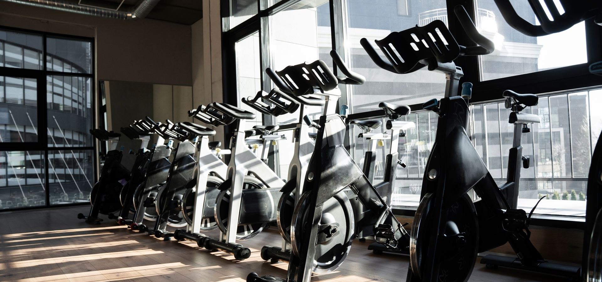 Row of spin bikes in a sunlit cycling studio